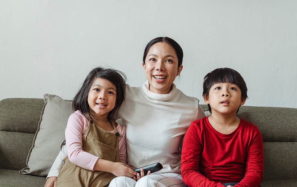 Family watching movie on couch together